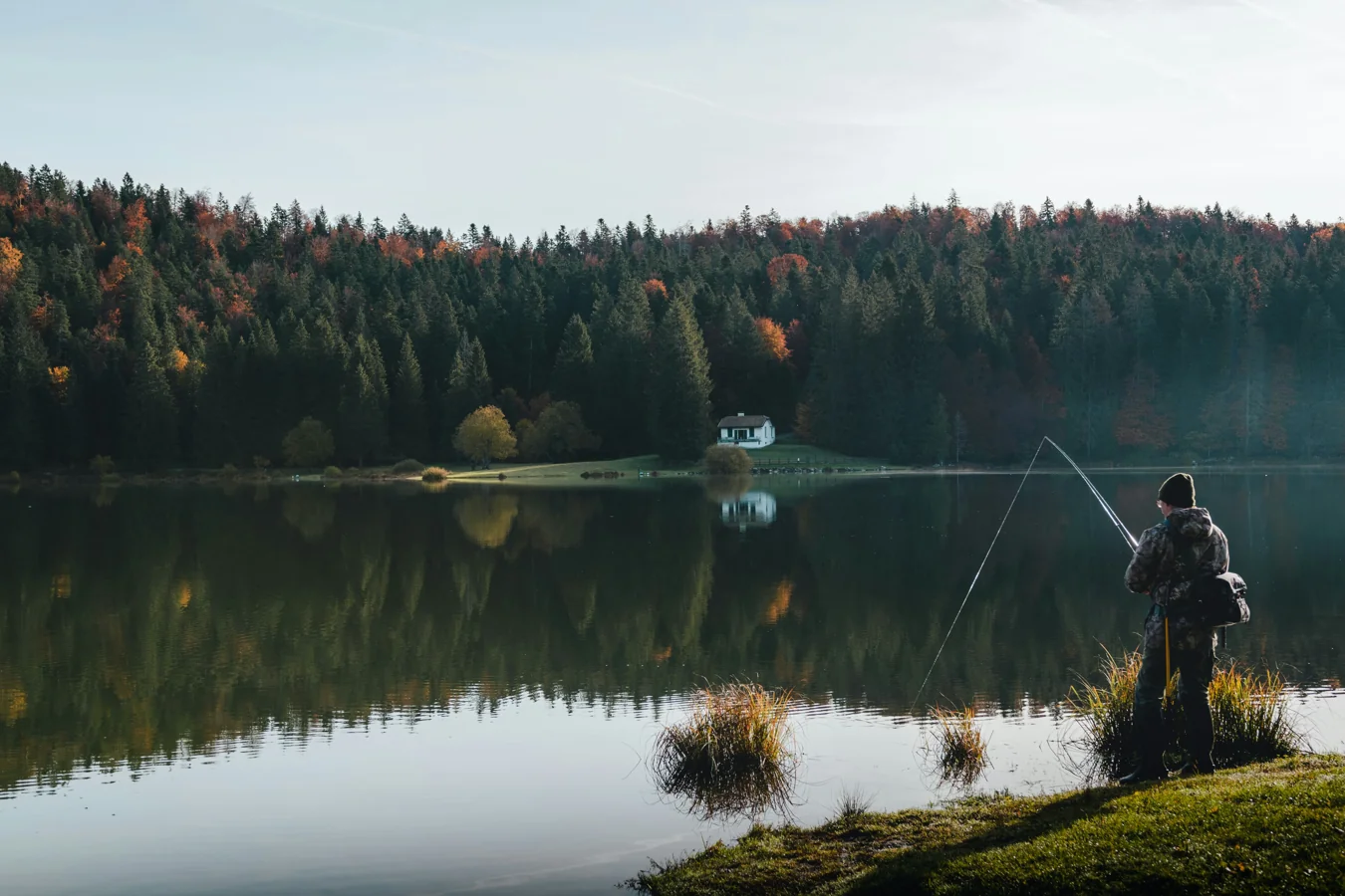 Person fishing alone at golden hour on a quiet lake